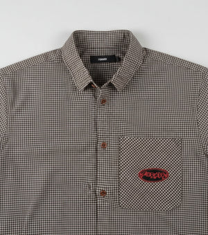Close-up of a checkered shirt with a brand logo on a white background